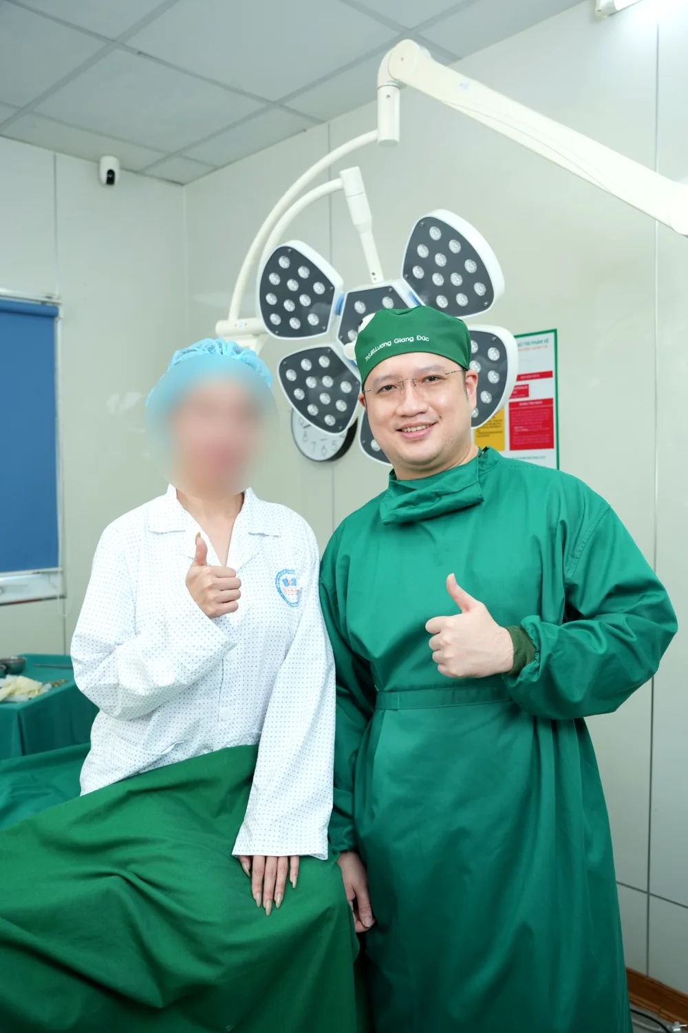 Bác sĩ Giang Đức chụp ảnh cùng khách hàng tại phòng mổ bệnh viện, trong môi trường y tế chuyên nghiệp